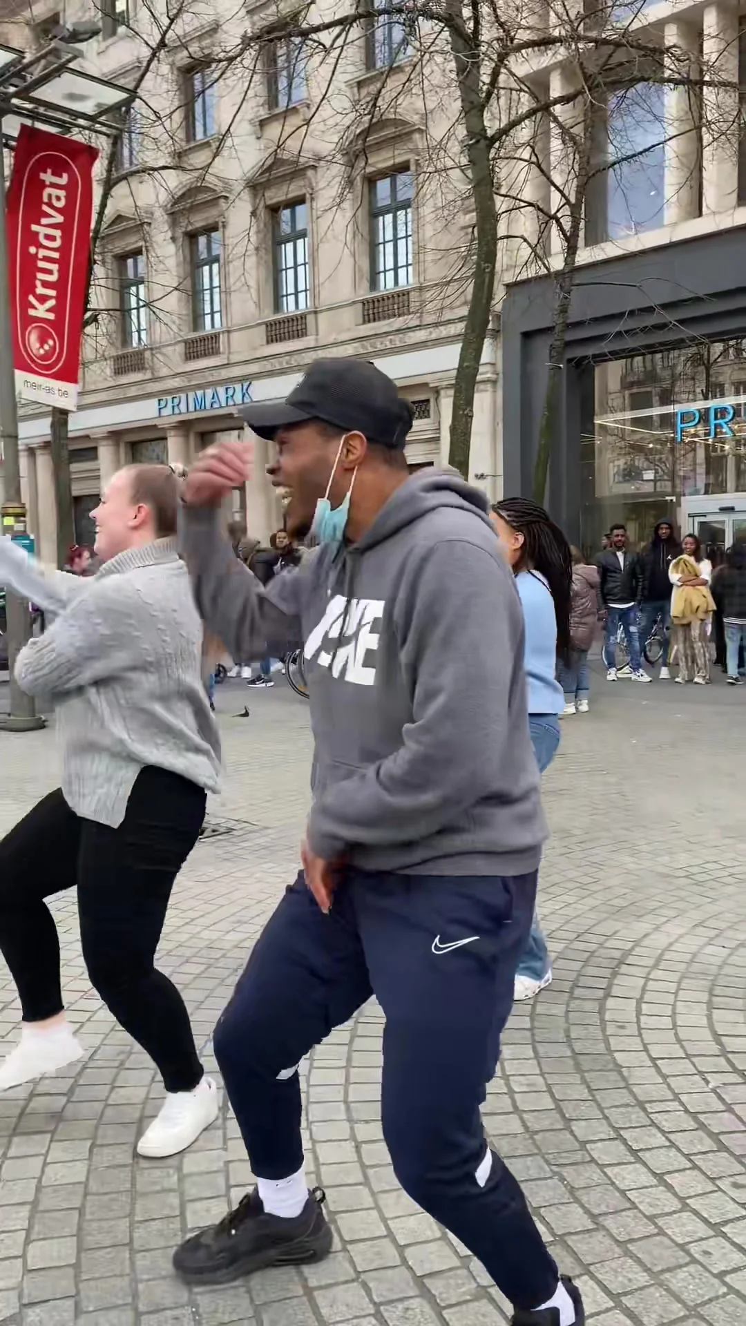 A man and a woman dancing together on the Meir, laughing