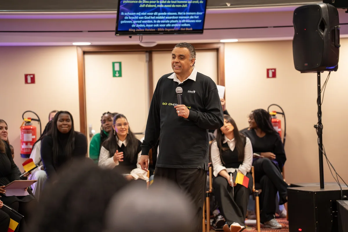 Bishop Dag Heward-Mills speaking with a microphone to young adults seated around him at a Go Church camp.