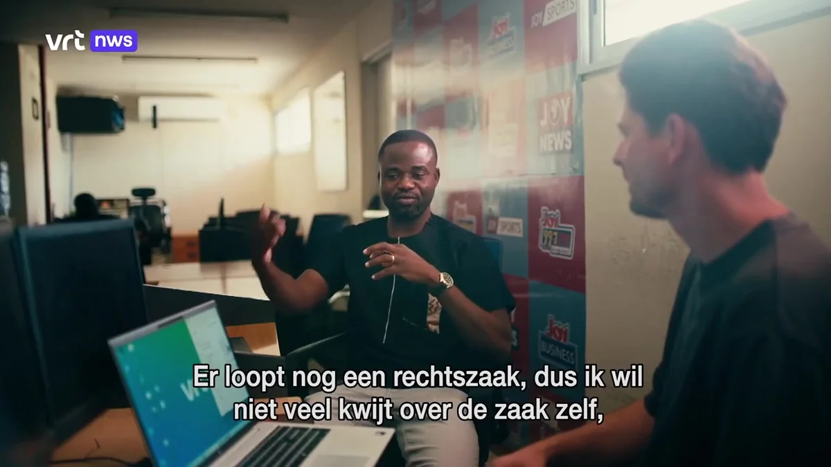 Manasseh Azure Awuni in a newsroom, interviewed by VRT, with the subtitle: there is still a court case.